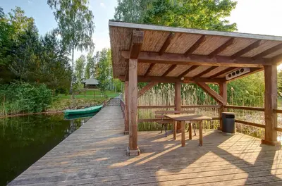 a wooden pier with a table and chairs on it at Prie Klykio in Utena