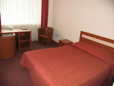 a bedroom with a bed and a desk and a chair at Hotel Ode Self Check-In in Alytus