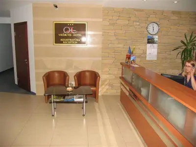 a woman sitting at a counter in a waiting room at Hotel Ode Self Check-In in Alytus