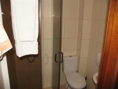 a small bathroom with a toilet and a shower at Hotel Ode Self Check-In in Alytus
