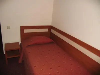 a bedroom with a bed with a red comforter at Hotel Ode Self Check-In in Alytus