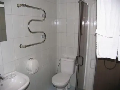 a bathroom with a shower and a toilet and a sink at Hotel Ode Self Check-In in Alytus