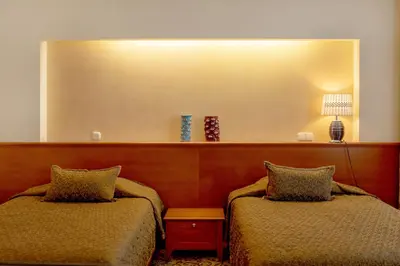 a room with two beds and a large mirror at Pažaislis Park Hotel in Kaunas