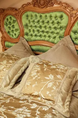 a close up of a bed with a green headboard at Pažaislis Park Hotel in Kaunas