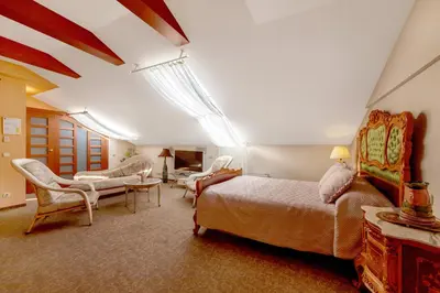 a bedroom with a king sized bed and a living room at Pažaislis Park Hotel in Kaunas