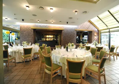a dining room with white tables and chairs at Hotel Senas Namas in Alytus