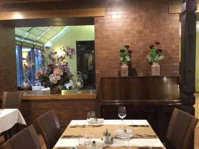 a dining room with tables and flowers on the wall at Hotel Senas Namas in Alytus