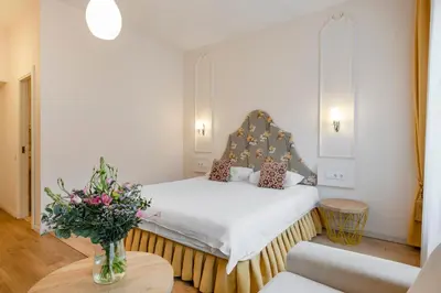 a bedroom with a bed with a vase of flowers on a table at Vilnius Apartments in Vilnius