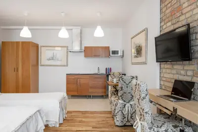 a bedroom with a bed and a desk with a laptop at Vilnius Apartments in Vilnius