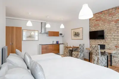 a bedroom with two beds and a brick wall at Vilnius Apartments in Vilnius