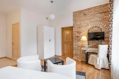 a bedroom with a brick wall and a table and chairs at Vilnius Apartments in Vilnius