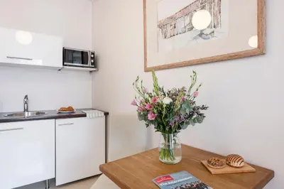a vase of flowers on a table in a kitchen at Vilnius Apartments in Vilnius