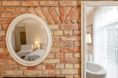 a brick wall with a mirror in a room at Vilnius Apartments in Vilnius