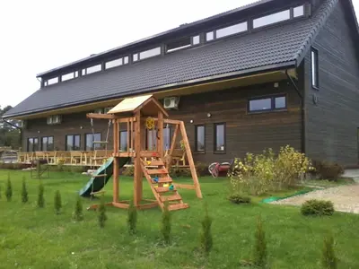 a playground in front of a wooden house at Love Island 2 in Druskininkai