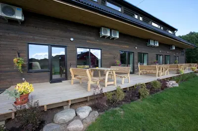 a wooden deck with benches and a table in front of a house at Love Island 2 in Druskininkai