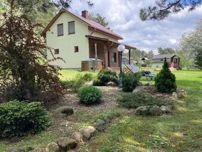 a house with a garden in front of it at Holiday Homes Eliza in Druskininkai