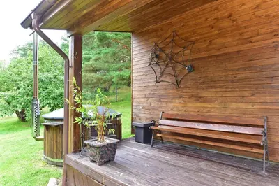 a wooden deck with a bench and a table at Holiday Homes Eliza in Druskininkai