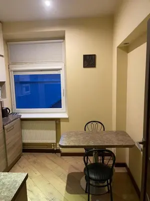 a dining room with a table and a window at Gintautas apartment in Šiauliai