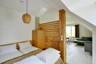 a bedroom with a bed and a living room at Draugų namai in Druskininkai