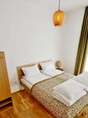 a bed with two pillows on it in a room at Draugų namai in Druskininkai