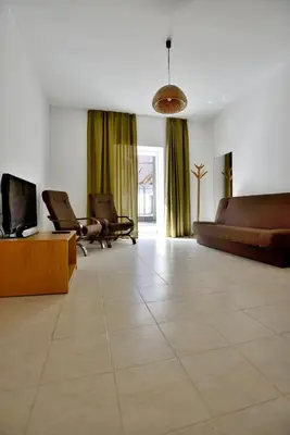 a large living room with a couch and a tv at Draugų namai in Druskininkai