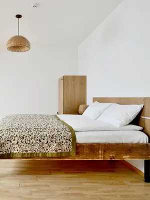 a bedroom with a bed with a wooden headboard at Draugų namai in Druskininkai