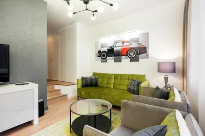a living room with a green couch and a car on the wall at Luxury for everyone - Hills Park Lux Apartments 2 in Vilnius
