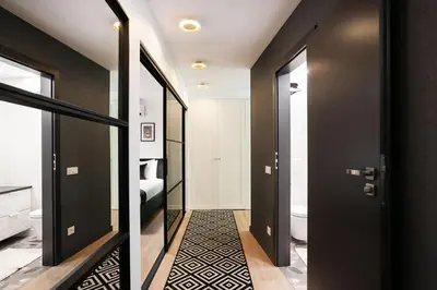 a hallway with black doors and a bathroom at Luxury for everyone - Hills Park Lux Apartments 2 in Vilnius
