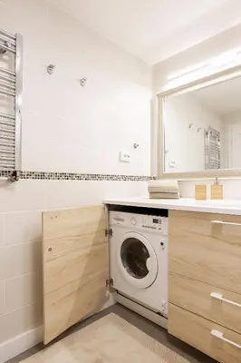 a washing machine in a bathroom with a mirror at Luxury for everyone - Hills Park Lux Apartments 1 in Vilnius