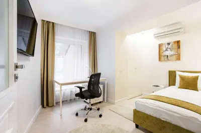 a bedroom with a bed and a desk and a chair at Luxury for everyone - Hills Park Lux Apartments 3 in Vilnius