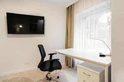 a desk and a chair in a room with a window at Luxury for everyone - Hills Park Lux Apartments 3 in Vilnius