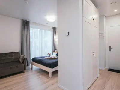 a bedroom with a bed and a couch and a window at J14A I Rooms & Apartments AUTOMATED SELF CHECK-IN in Vilnius