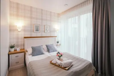 a bedroom with a bed with a vase of flowers on it at J14A I Rooms & Apartments AUTOMATED SELF CHECK-IN in Vilnius