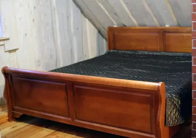 a bedroom with a wooden bed in a room at Sodyba pas Olgą in Mickūnai