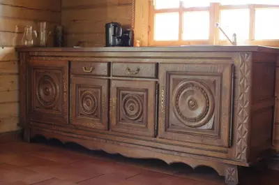 an old wooden cabinet in a kitchen with a window at Sodyba pas Olgą in Mickūnai