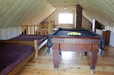 a room with a pool table in a attic at Sodyba pas Olgą in Mickūnai
