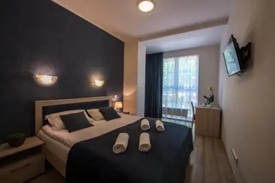 a bedroom with a bed with slippers on it at Sanatorija ,,Tulpės
