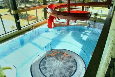 a swimming pool with two people swimming in it at Sanatorija ,,Tulpės