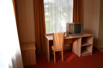 a room with a desk with a television and a chair at Vila Evelina in Druskininkai