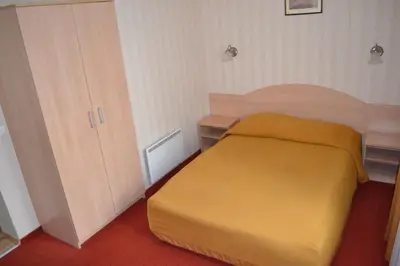 a bedroom with a yellow bed and a cabinet at Vila Evelina in Druskininkai