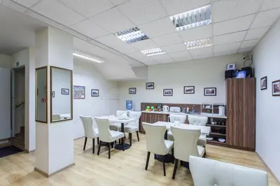 a dining room with a table and white chairs at Silvija House in Vilnius