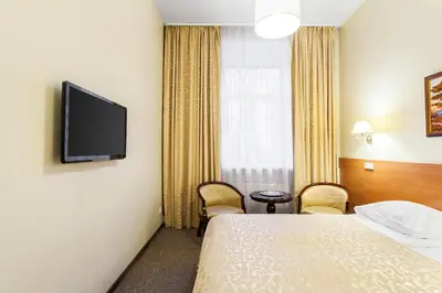 a hotel room with a bed and a flat screen tv at Silvija House in Vilnius