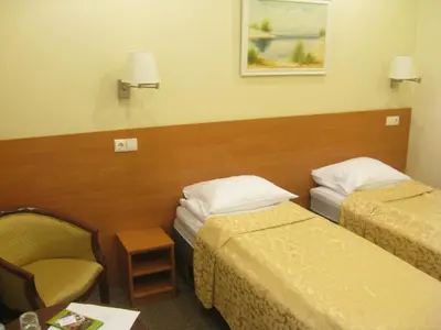 a hotel room with two beds and a chair at Silvija House in Vilnius