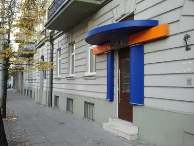 a blue and orange sign on the side of a building at Silvija House in Vilnius