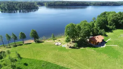 an aerial view of a house on the shore of a lake at Mekų vila in Degučiai