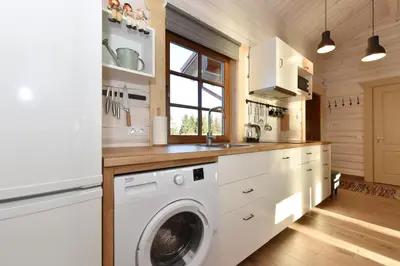 a kitchen with a washing machine and a sink at Mekų vila in Degučiai