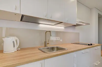 a kitchen with white cabinets and a sink at Center Apartment 10A in Vilnius