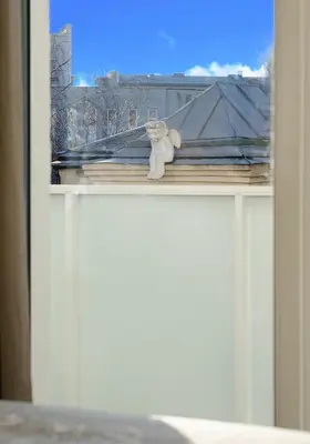 a teddy bear sitting on the ledge of a window at Center Apartment 10A in Vilnius