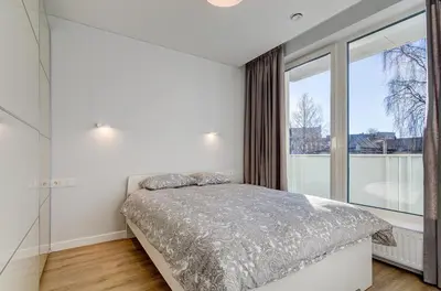 a bedroom with a bed and a large window at Center Apartment 10A in Vilnius