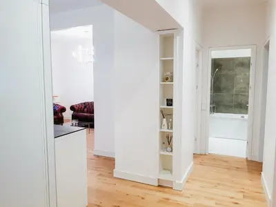 a living room with white walls and a white kitchen at Islandijos gatvė in Vilnius